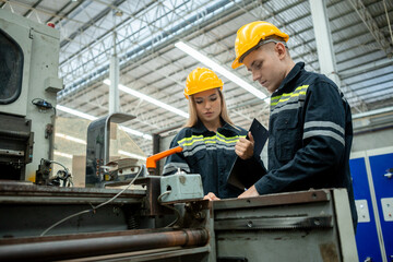 Workers inspecting machines in a paper mill. Large industry in paper production line.