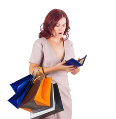 Shocked woman shopaholic carrying bags holding her empty wallet. Young female has no money in her pouch for shopping