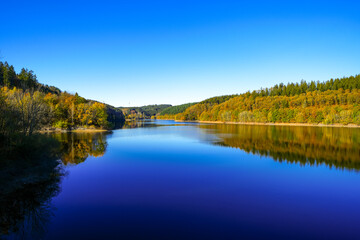 Obraz premium View of the Oleftalsperre Dam and the surrounding landscape. Nature at the lake near the Eifel National Park near Hellenthal in the Hohes Venn-Eifel Nature Park. 