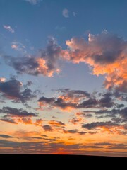 Fototapeta premium Beautiful orange sunset. The sun's rays look through the clouds. Evening hour.