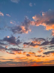 Beautiful orange sunset. The sun's rays look through the clouds. Evening hour.