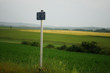 Water depth sign in countryside landscape with crop fields