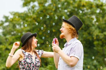 Couple blowing soap bubbles, having fun