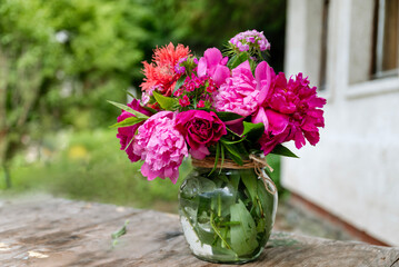 Beautiful bouquet of summer peonies flowers in a glass vase 