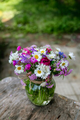 Glass vase with beautiful bouquet of summer wild flowers