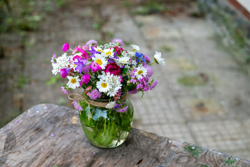Glass vase with beautiful bouquet of summer wild flowers