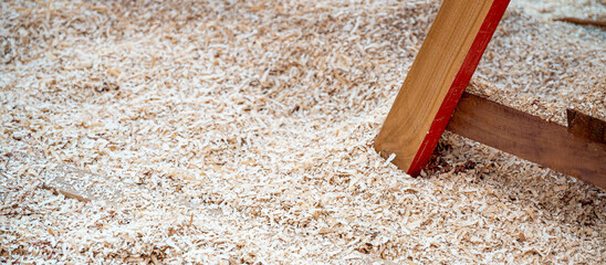 Sawdust heap under workbench leg in the wood workshop. Wooden dust from planing and sawing timber. Wood production waste. lumber industry concept