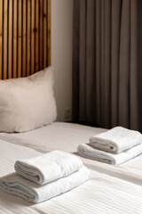 Modern hotel bedroom designed for comfort with neatly arranged towels