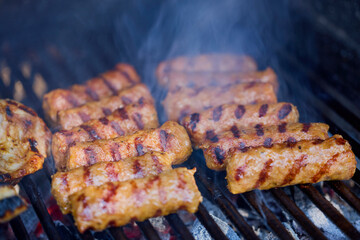 (Mici), traditional Romanian meat dishes on a grill during the cooking