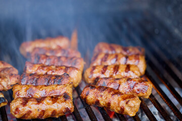 (Mici), traditional Romanian meat dishes on a grill during the cooking