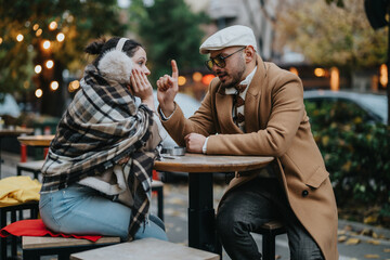 A couple enjoying a warm conversation outdoors, wrapped in cozy attire at a cafe. Surrounded by autumn scenery and soft lights, they share a moment of comfort and connection.