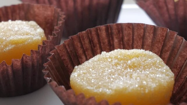 Sugary yellow sweet in brown wrapper, traditional Spanish egg yolk dessert