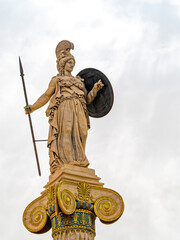 Statue of Athena, the ancient Greek goddess of wisdom and warfare, standing tall with her helmet, shield, and spear, embodying strength and intellect in Athens, Greece.