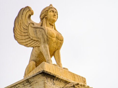 Sphinx sculpture, an ancient Greek mythical creature with the head of a woman, the body of a lion, and eagle wings, symbolizing wisdom and mystery. Space for text and logo.
