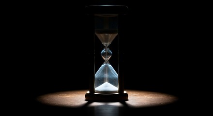 Hourglass Sands Flowing Under Spotlight Revealing Passage of Time