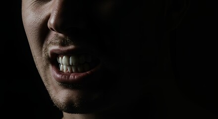 Man Gritting Teeth with Angry Expression in Low Key Lighting
