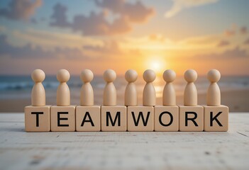Wooden figurines standing on blocks spelling teamwork against a sunset beach background