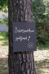 tafel am baum mit dem hinweis: biergarten geöffnet