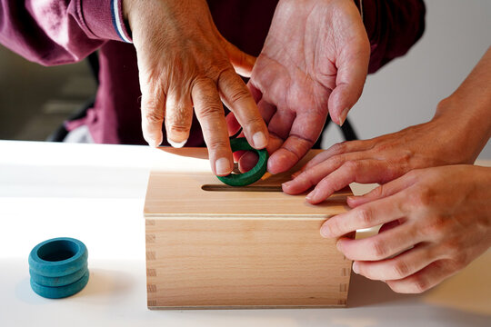 ALS patient assisted with fine motor skill exercise