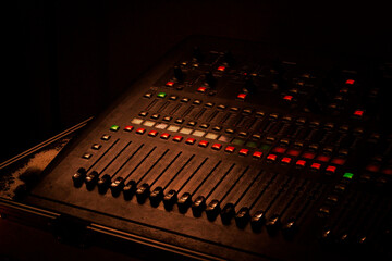 Mesa de som profissional com luz dramática em estúdio / Professional mixing console with dramatic...