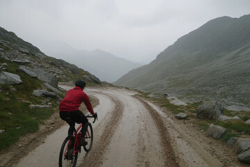 Cycling through a foggy landscape on a winding mountain road