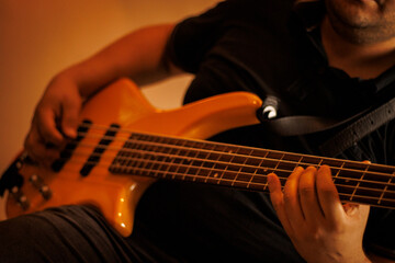 Músico tocando contrabaixo elétrico em estúdio de gravação / Musician playing electric bass guitar in recording studio