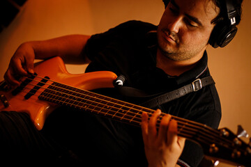 Músico tocando contrabaixo elétrico em estúdio de gravação / Musician playing electric bass guitar in recording studio