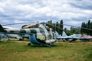 Military Helicopter and Aircraft Displayed Outdoors in an Aviation Museum