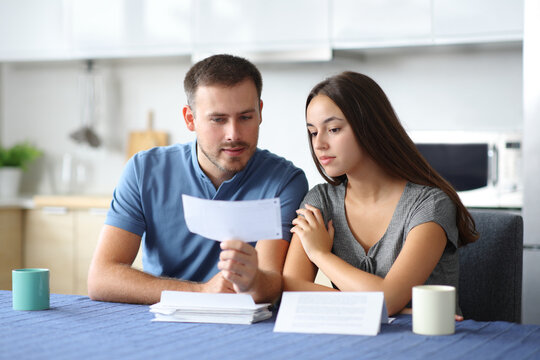 Seriour couple checking bank statement in a kitchen