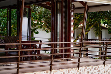 Modern Patio With Wooden Furniture Surrounded by Lush Tropical Plants