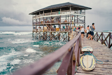 Rustic Pier with Surfboards Leading to a Scenic Beach House