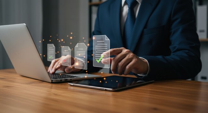 Businessman reviews digital documents with approval check marks on a laptop and tablet at his desk