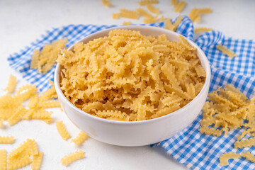 Raw Mafaldine pasta with ingredient for cooking