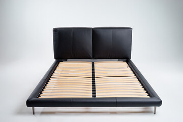 Elegant black bed frame featuring a slatted wooden base and padded headboard, designed for...