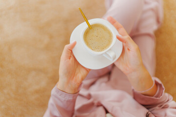 faceless woman with a cup of coffee on the beige Interior pile carpet.