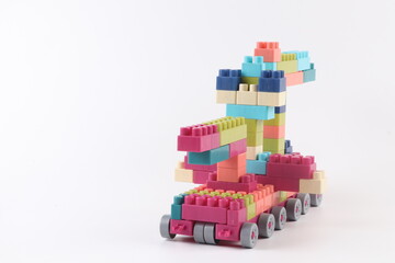 Fototapeta premium Plastic building blocks form vehicle on white background.