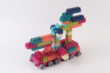 Fototapeta premium Plastic building blocks form vehicle on white background.