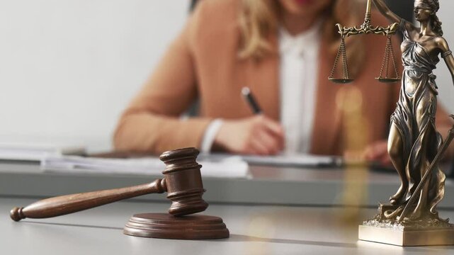 Woman judge lawyer, notary, advocate blurred in background. symbols of justice: scales, statue of Themis, gavel. Gifts for lawyer. worker in jurisprudence, legislation, lawmaking judge makes decision