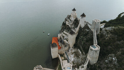 Aerial view of Golubac Fortress on rocky cliff above the Danube River in Serbia, surrounded by...