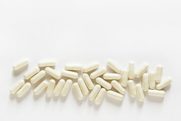 White capsules scattered on white background. different pills and tablets, medication...