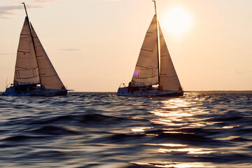 Sailing regatta in the Gulf of Finland at sunset, two sailing yachts competing in a race, splashing...