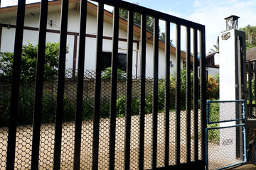 Iron gate in front of the house and small PVC gate to keep out dogs