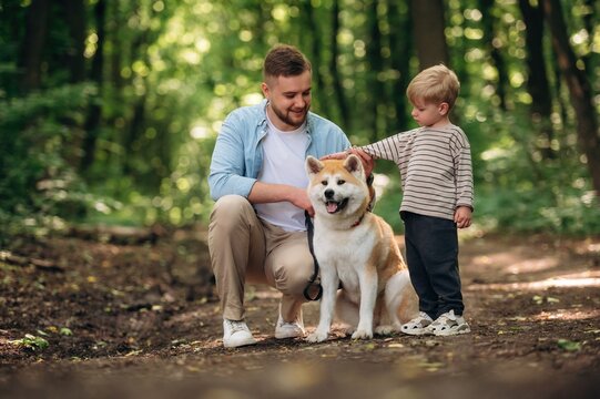 Father with son and dog are in the forest