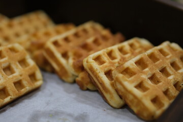 Waffle topped with honey sauce on blue plate at cafe. Flat lay of Sweet bakery on dish with copy space. Snack on table. High quality photo
