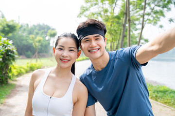 Fitness couple taking selfie after exercising outside in park on a sunny day Smiling portrait