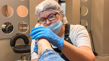 North European woman diligently pampers a client's feet in a serene salon, celebrating Global...