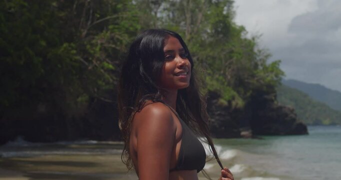 The Caribbean sun shines down on a young East Indian girl enjoying the beach in her bikini.