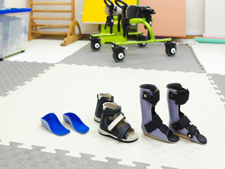 Supportive footwear and mobility aids are organized for children's physical rehabilitation activities in physical therapy clinic