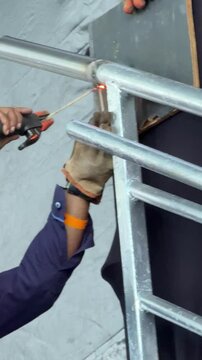 man welding iron and steel pipes