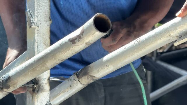 close-up of a man welding steel pipes